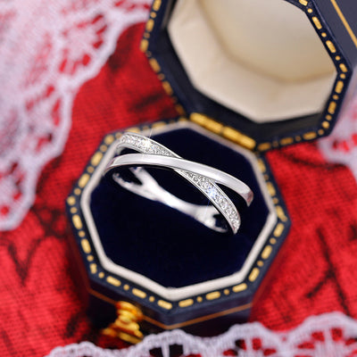 White metal crisscross clear stone ring in navy gold jewelry box