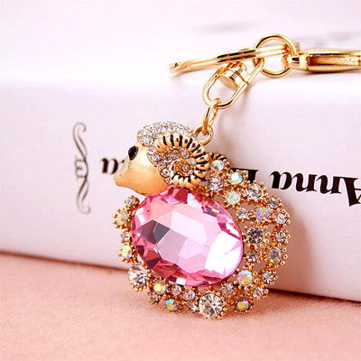 Pink faceted oval ram ornament surrounded by clear and iridescent rhinestones.