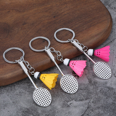 Three badminton racket keychains paired with yellow and pink shuttlecock charms.