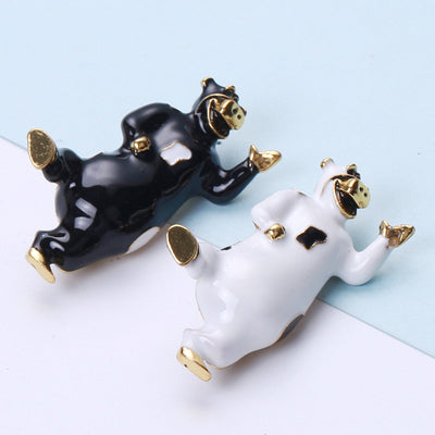 Product image 1 showing the glossy dancing cow brooch in black or white enamel.