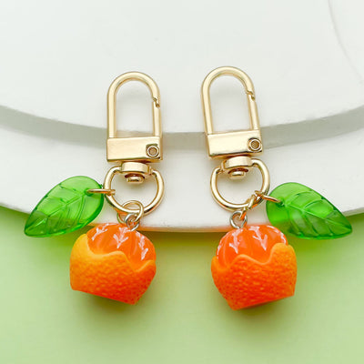 Image 1 showing a pair of oranges with green leaves on them.