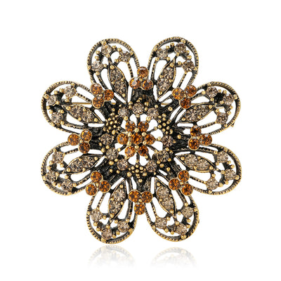 Multicolor Flower, Iridescent Flower, Antique Gold Flower, Black Flower brooch styles arranged on a light display