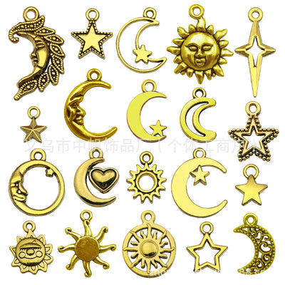 Matte gold-tone moon and sun charms arranged on a light background