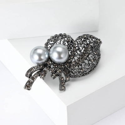 Front view of the gray crystal leaf bouquet brooch with pearls with polished metal detail on a white background