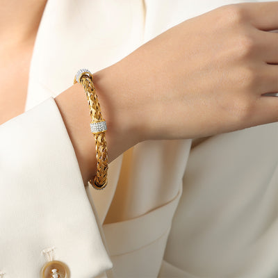 Model wearing gold braided cuff with crystal rings on wrist