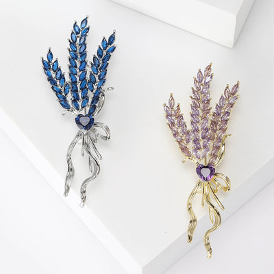Blue and purple crystal wheat stalk brooches on white