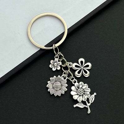 Front product photo of antique silver sunflower and cherry blossom charm keychain showing the pictured design arrangemen