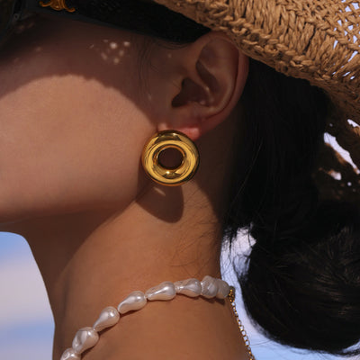 Gold hollow circle dome stud worn with straw hat outdoors
