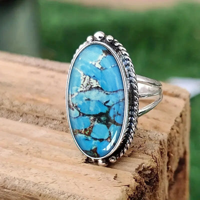 Antique silver oval blue matrix cabochon ring on wood outdoor close-up