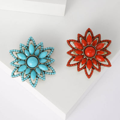 Front view of layered floral cabochon brooch in turquoise blue and red
