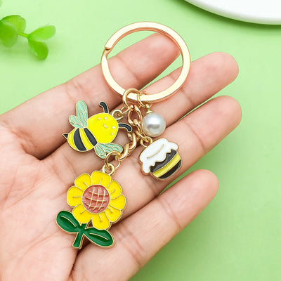 Image 1 showing a hand holding a keychain with flowers and birds.
