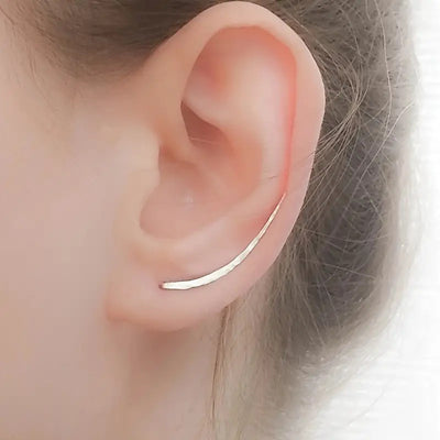 Product view showing curved textured ear climber earrings