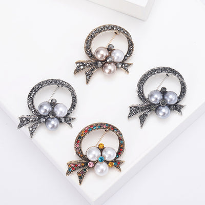 bow and pearl wreath brooch group view
