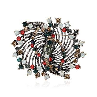 Front view of a coiled circular brooch with mixed red green and clear bead accents