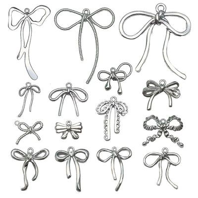 Silver-tone bow and butterfly charms arranged on a light background