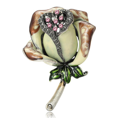 Front view of sculpted rosebud with cream petals, brown edges, and a pink crystal center