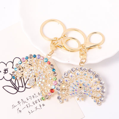 Multicolor and clear AB rhinestone peacock keychains side by side