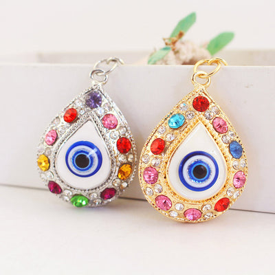 Silver-tone and gold-tone teardrop eye charms displayed side by side.