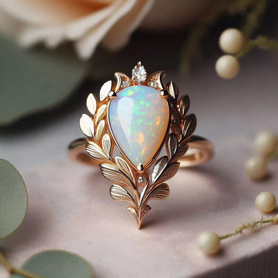 Front studio shot of champagne gold leaf teardrop opal ring