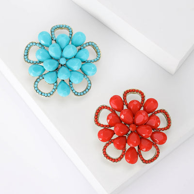 Rounded enamel petals bordered by small clear crystals brooch front view