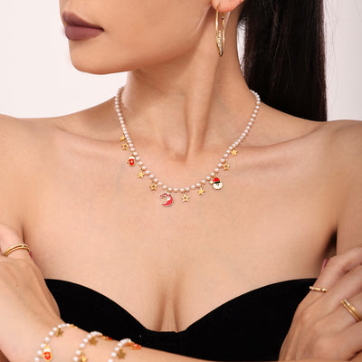 Coordinated set view of pearl Christmas charm necklace and bracelet in main image 1.