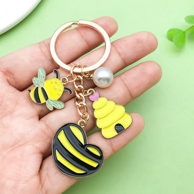 Image 1 showing a hand holding a keychain with two bees.