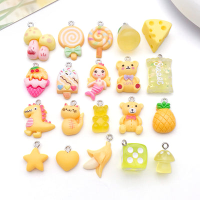 Yellow lollipop and heart charms arranged on a light background