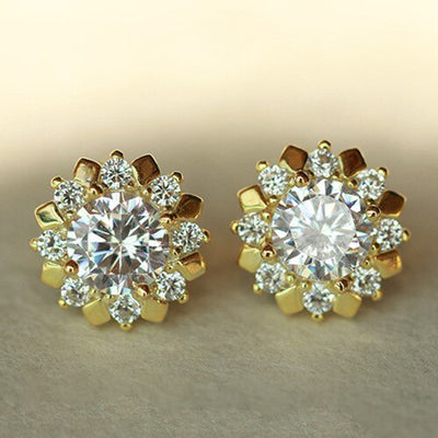 Gold sunflower clear center stud earrings pair on beige fabric