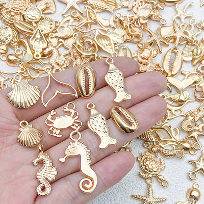 Gold-tone shell and starfish charms arranged on a light background
