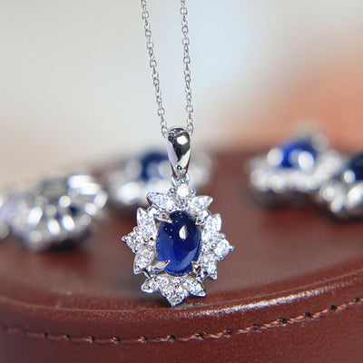 Blue oval floral halo pendant on brown leather with chain