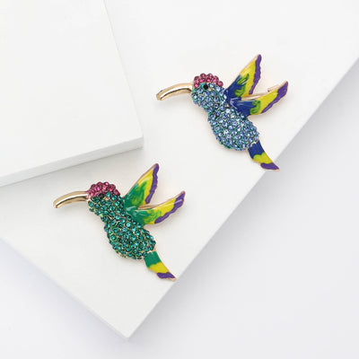 Front view of a flying hummingbird covered with bright crystals