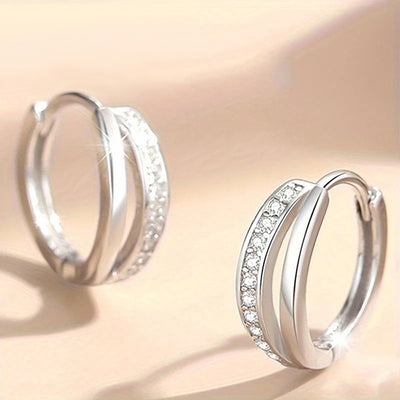 Silver twisted channel crystal huggie hoops pair on beige