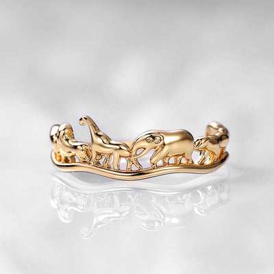 Gold animal parade openwork band ring on white surface