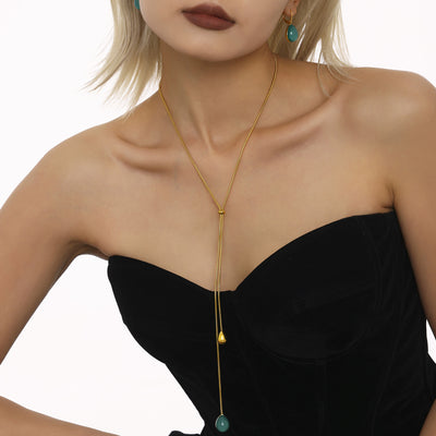 Model wearing gold Y-lariat with teal resin teardrop pendant