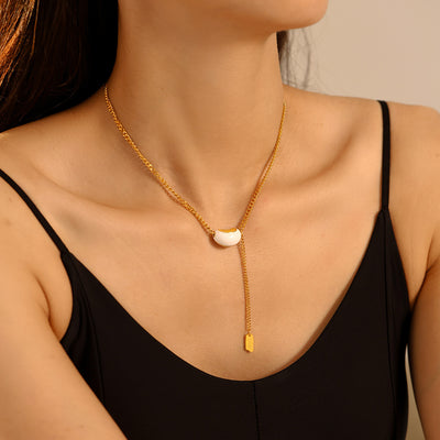 Model wearing gold white bean lariat necklace with tag drop