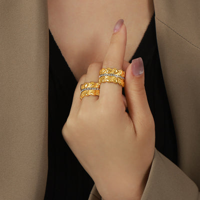 Model wearing two gold heart-relief crystal channel rings