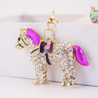 Gold-tone horse charm with clear rhinestones, pink mane and pink tail viewed from the side.