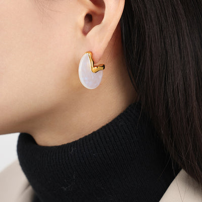 Model wearing gold wavy metal white resin disc stud earring