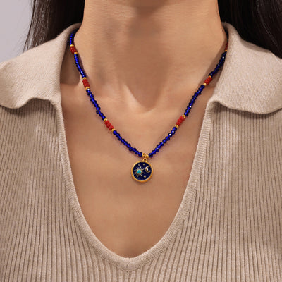 Blue crystal bead necklace with star-moon pendant worn on neck