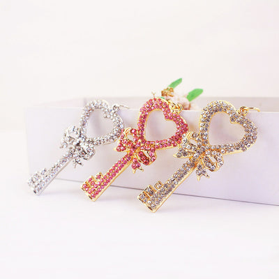 Three rhinestone heart key charms in pink, gold-tone clear, and silver-tone clear finishes.