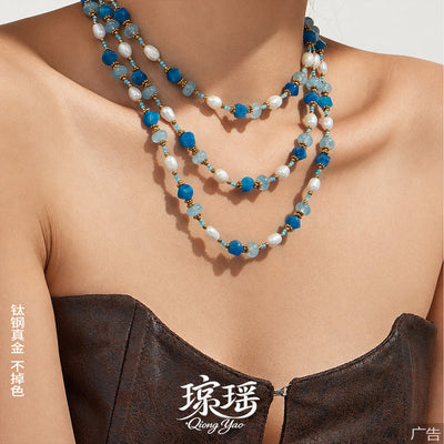 Neckline view of aquamarine color stone and freshwater pearl necklace in main image 1.