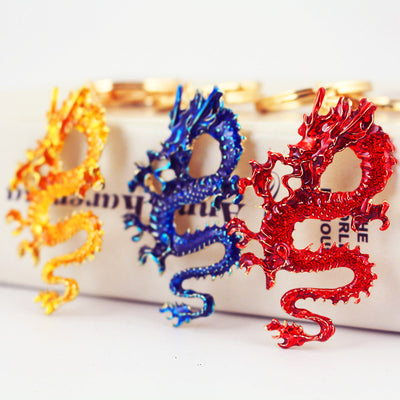 Red, blue, and gold Chinese dragon keychains displayed together.