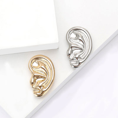 sculptural ear brooch in gold or silver tone finish isolated on a white background