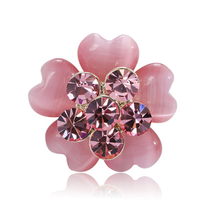 Pink cat-eye petal flower brooch with rhinestone center on white