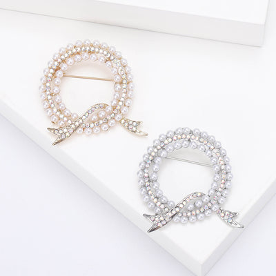 Front view showing the circular faux pearl wreath brooch with crystal leaf accents