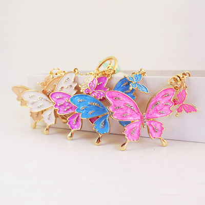 Four colorful butterfly keychains arranged together on a white display.