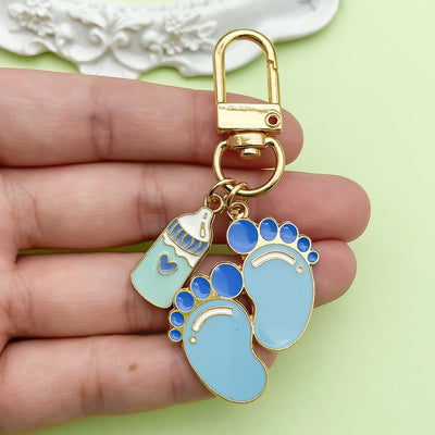 Image 1 showing a person holding up two blue and white dog paw charms.