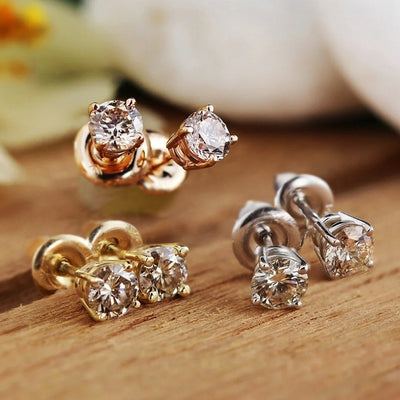 Three pairs of round CZ studs in gold rose gold and silver on wood