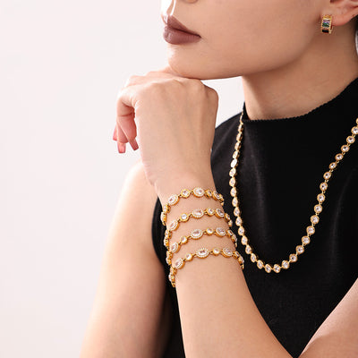 Model stacking four gold oval halo zircon bracelets
