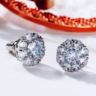 Silver flower halo clear stud earrings pair on white with copper tray